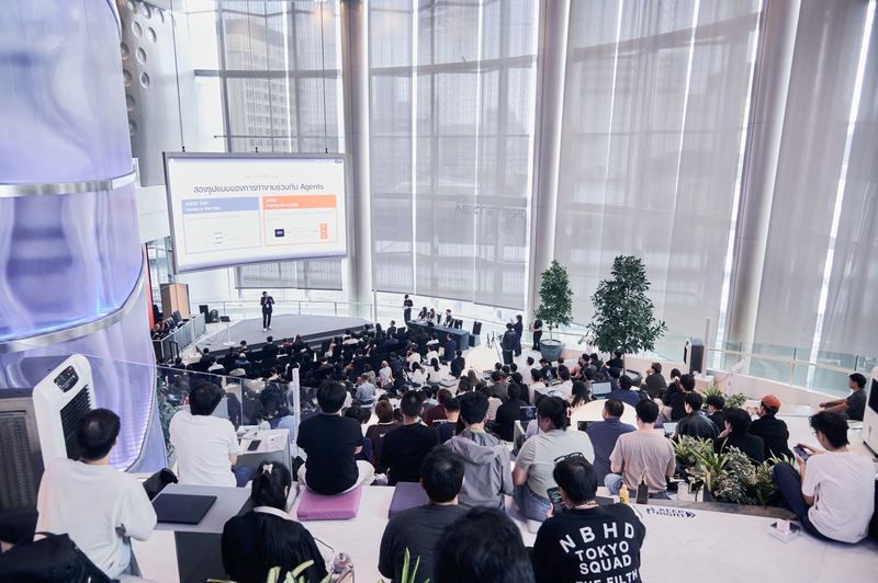 มุมจากอัฒจันทร์ด้านบน เห็นผู้ฟัง เวที และสไลด์บนจอ