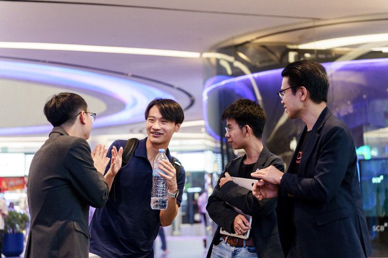 ผู้ร่วมงานยืนพูดคุยแลกเปลี่ยนกันระหว่างงาน