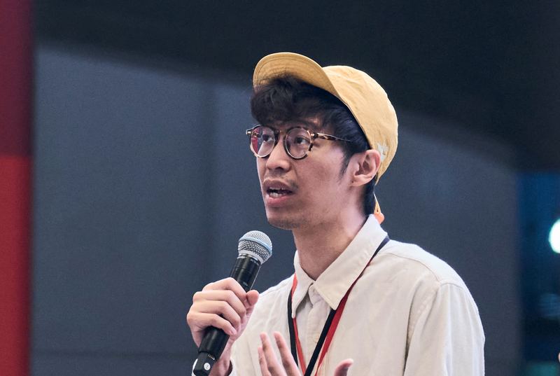 คุณกษิดิศ สตางค์มงคล ถือไมโครโฟนพูดระหว่างเสวนา
