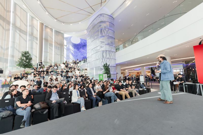 คุณ Phatrasek บรรยายบนเวที มองจากด้านหลังเวทีเห็นผู้ฟังนั่งเต็มพื้นที่