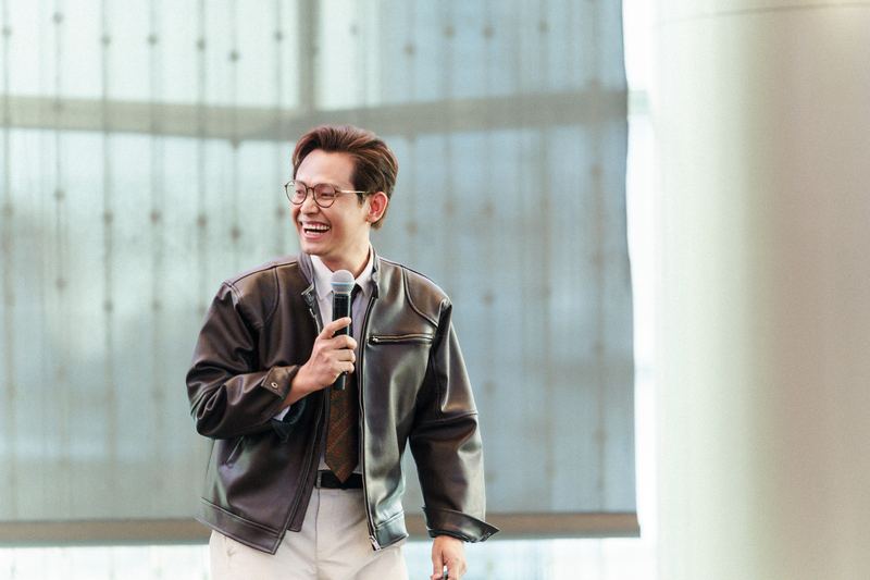 คุณการันต์ แป้นทอง ถือไมโครโฟนและหัวเราะระหว่างบรรยาย